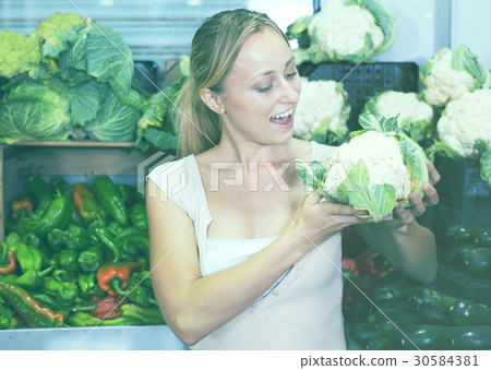 young woman buying cabbage at market. young woman buying cabbage at market. 30584381
