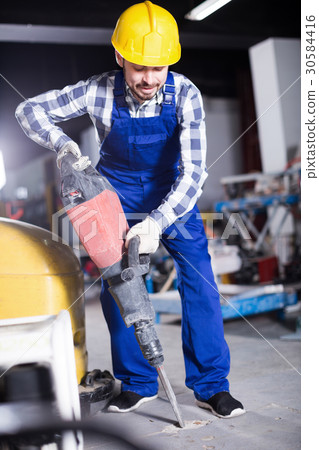 Young smiling man worker using jackhammer Young smiling man worker using jackhammer 30584416