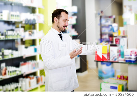 Male pharmacist searching for reliable drug Male pharmacist searching for reliable drug 30584500
