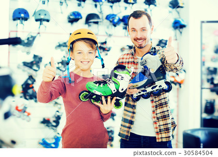Laughing man and son boasting roller-skates Laughing man and son boasting roller-skates 30584504