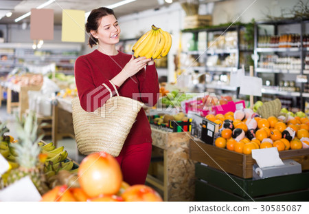 Portrait of happy customer selecting bananas in grocery 30585087
