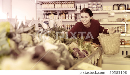 Girl buys a variety of vegetables Girl buys a variety of vegetables 30585198