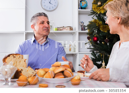 Mature couple having breakfast at festive Christmas table Mature couple having breakfast at festive Christmas table 30585354