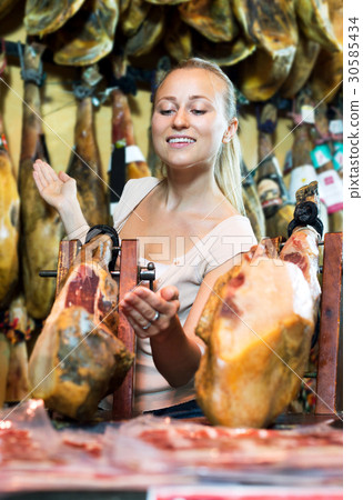 Woman picking delicious prosciutto meat 30585434