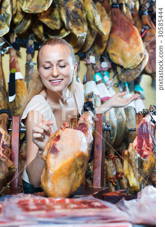 Positive female customer choosing iberian ham 30585444