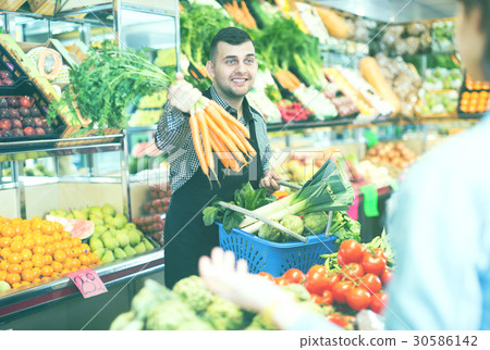 Male seller assisting in buying 30586142