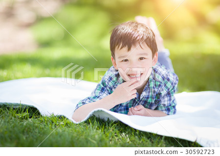 Mixed Race Chinese and Caucasian Young Boy Relaxing Outside On T 30592723