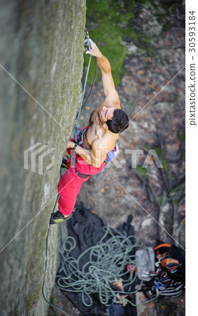 Muscular rock climber climbs on overhanging cliff 30593184