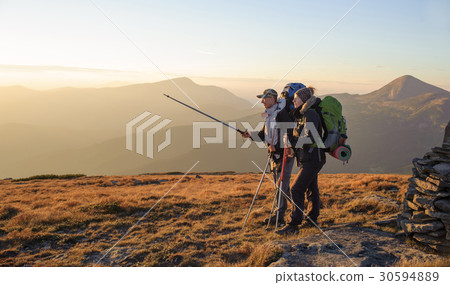 Couple hikers in the mountains with backpacks 30594889