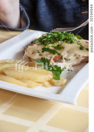 hands of the person eating the baked chicken 30594944