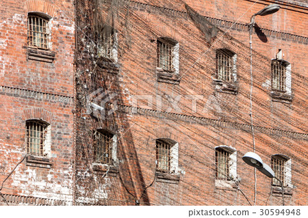 wall of prison with barred windows wall of prison with barred windows 30594948