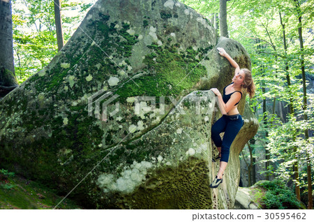 young woman climbing on large boulders outdoor young woman climbing on large boulders outdoor 30595462