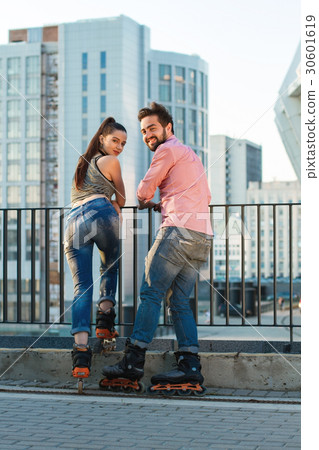Couple on rollerblades looking back. 30601619