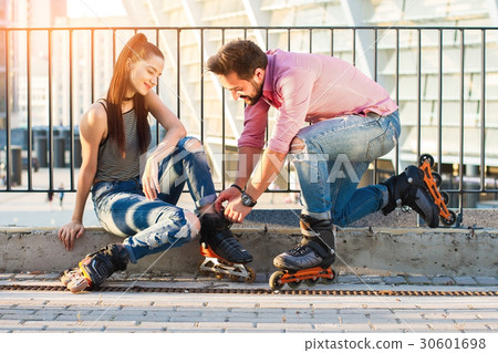 Woman and man wearing rollerblades. Woman and man wearing rollerblades. 30601698