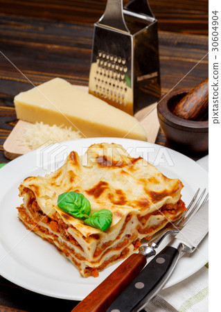 Portion of tasty lasagna on wooden backgound 30604904