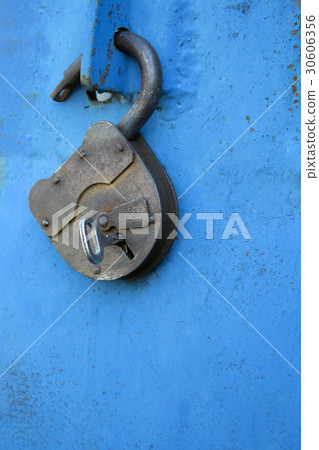 Old rusty lock with a key on a blue background 30606356