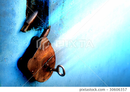 Old rusty lock with a key on a blue background Old rusty lock with a key on a blue background 30606357