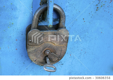 Old rusty lock with a key on a blue background 30606358