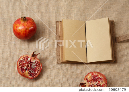 Granat Apple and Notebook lying on a sackcloth 30608479