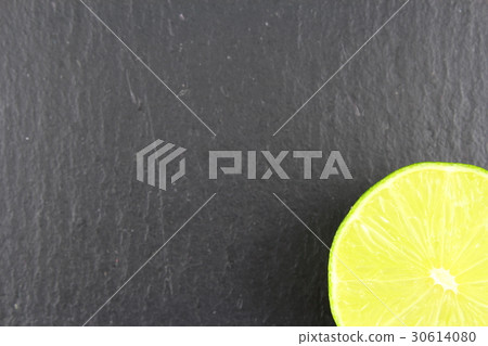 fresh lime fruit on a slate plate food background fresh lime fruit on a slate plate food background 30614080