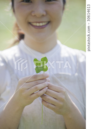 A woman with a four leaf clover A woman with a four leaf clover 30614613