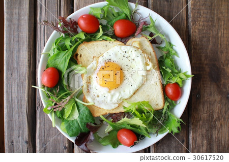 One-plate meal of toast topped with wreath salad and fried egg 30617520