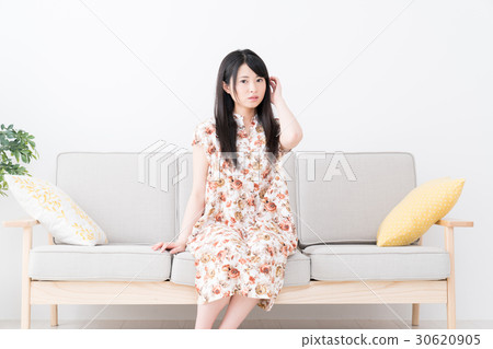 一位年輕的女士坐在沙發上 一位年輕的女士坐在沙發上 30620905