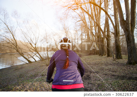 Brunette in helmet rides bicycle Brunette in helmet rides bicycle 30622637