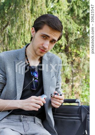 An ironic young businessman is picking a wipe An ironic young businessman is picking a wipe 30623547