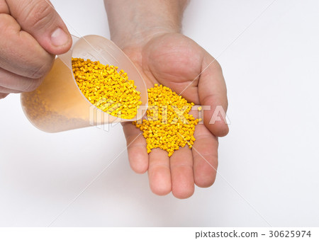 Plastic pellets spilled out of the measuring Cup 30625974