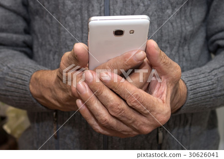 Elderly man standing with a mobile phone in hands Elderly man standing with a mobile phone in hands 30626041