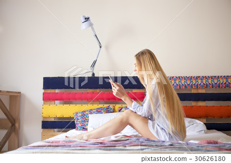 Happy blond taking a photo of herself by phone Happy blond taking a photo of herself by phone 30626180