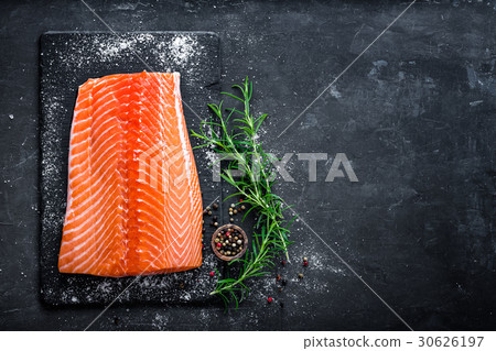 Raw salmon filet on dark slate background Raw salmon filet on dark slate background 30626197