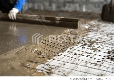 Worker making cement screed on the floor view 30629600
