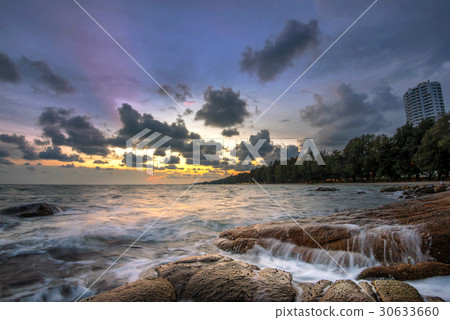 wave hitting rock  at sunset 30633660