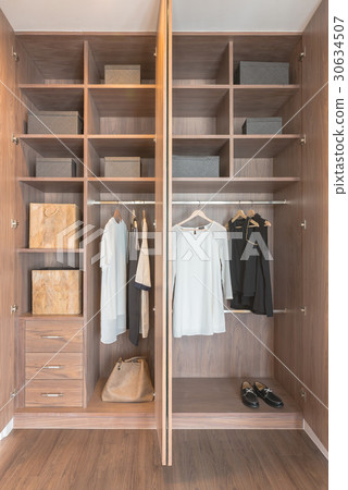 set of black and white clothes hanging on rail 30634507