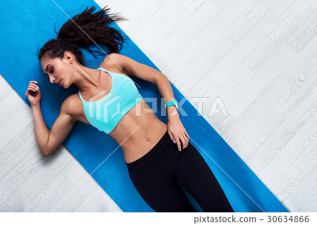 Top view of slim fitness model lying on mat 30634866