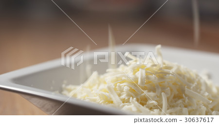 grated pizza mozzarella cheese falls in plate grated pizza mozzarella cheese falls in plate 30637617