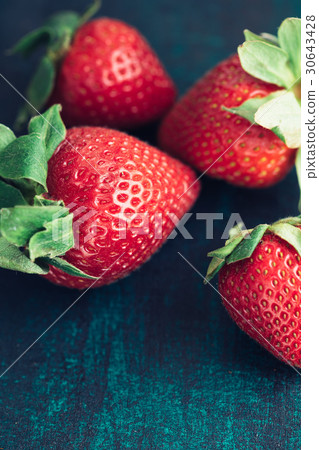 Fresh strawberries on a textured dark green board Fresh strawberries on a textured dark green board 30643428