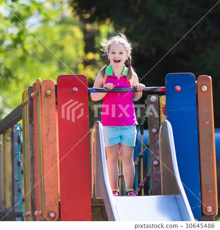 Child playing on outdoor playground in summer Child playing on outdoor playground in summer 30645486