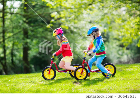 Kids ride balance bike in park Kids ride balance bike in park 30645613