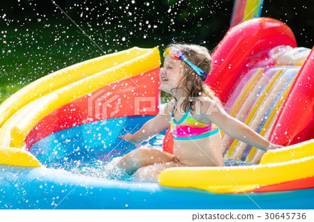 Child in garden swimming pool with slide 30645736