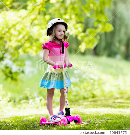 Little girl riding a colorful scooter 30645775