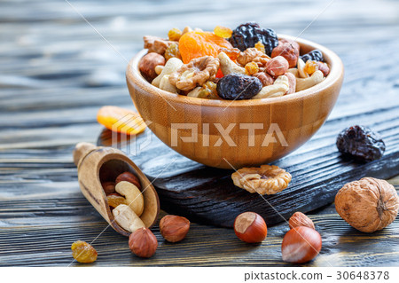 Dried fruits and nuts mixed in wooden bowl. 30648378
