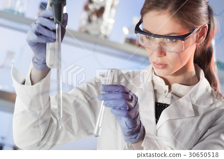 Young scientist pipetting in life science 30650518
