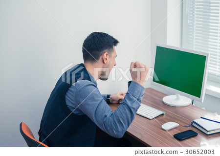 Furious young businessman ready to smash his 30652003