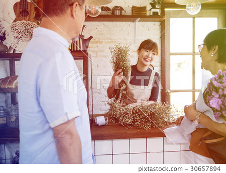 Young florist woman decorating flower bouquet Young florist woman decorating flower bouquet 30657894