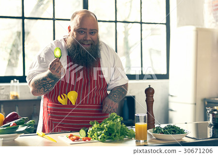 Joyful thick guy enjoying healthy food preparation Joyful thick guy enjoying healthy food preparation 30671206