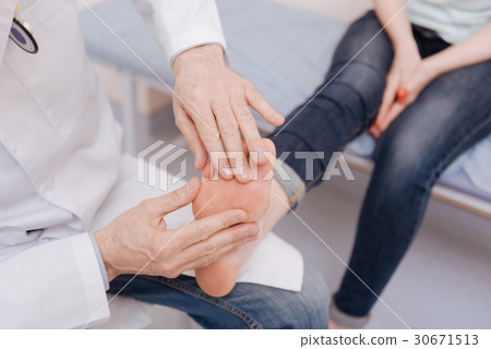 Delicate focused rheumatologist conducting special Delicate focused rheumatologist conducting special 30671513