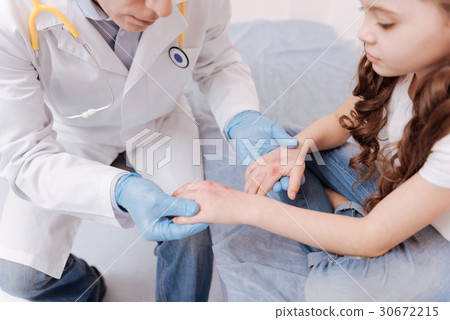Amusing little girl showing doctor her wounds 30672215